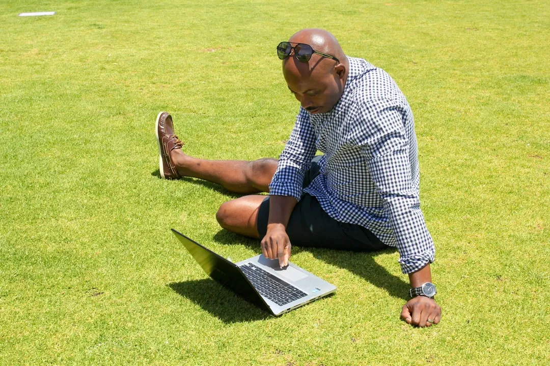 man in blue and white checkered button up shirt sitting on green grass field | Photo by Eric O. IBEKWEM on Unsplash