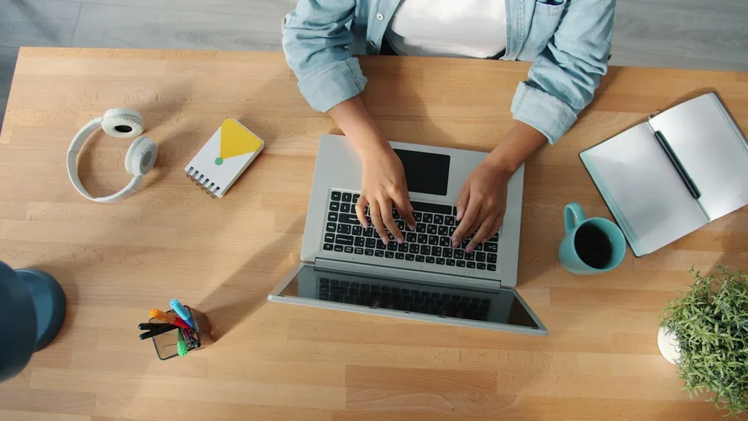 Person typing on a laptop at a wooden desk. | Photo by Vitaly Gariev on Unsplash