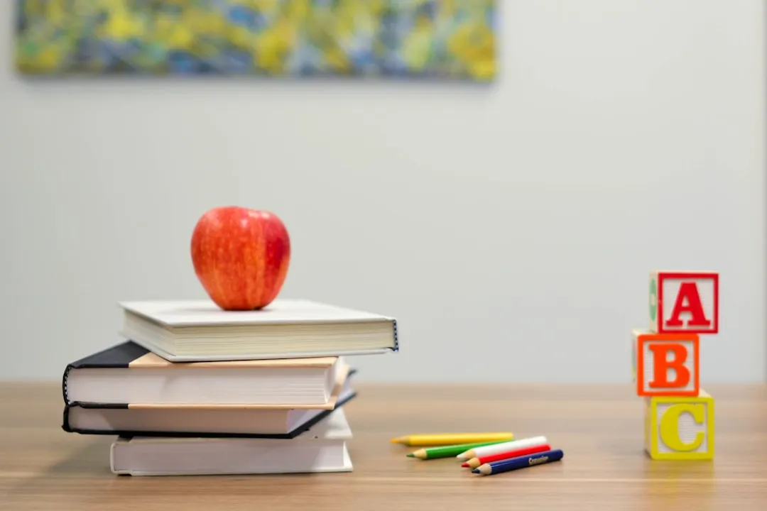 Child learning at a desk with a tablet and educational materials