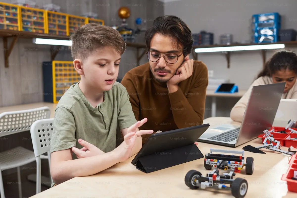 Child building a small robot with electronic components on a table