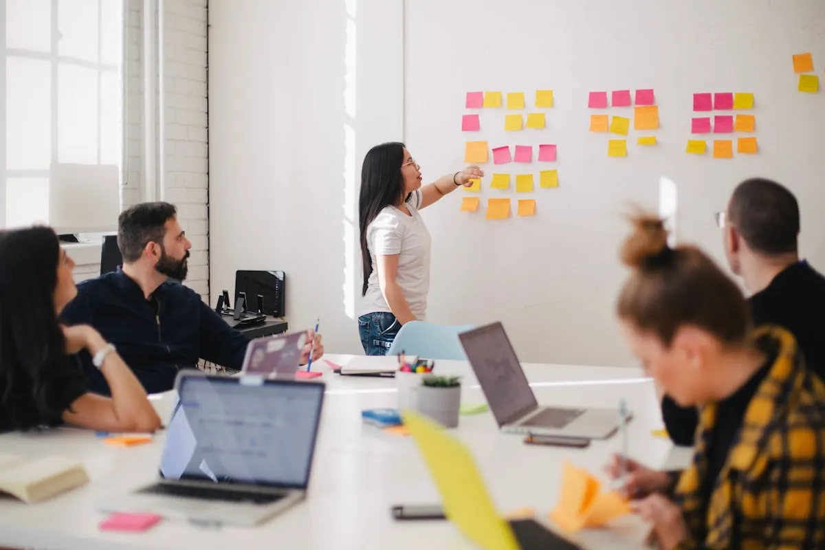 Team collaborating around a whiteboard in a modern office | Photo by Unsplash