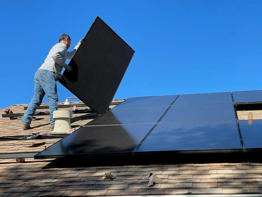 man in white dress shirt and blue denim jeans sitting on white and black solar panel | Photo by Bill Mead on Unsplash