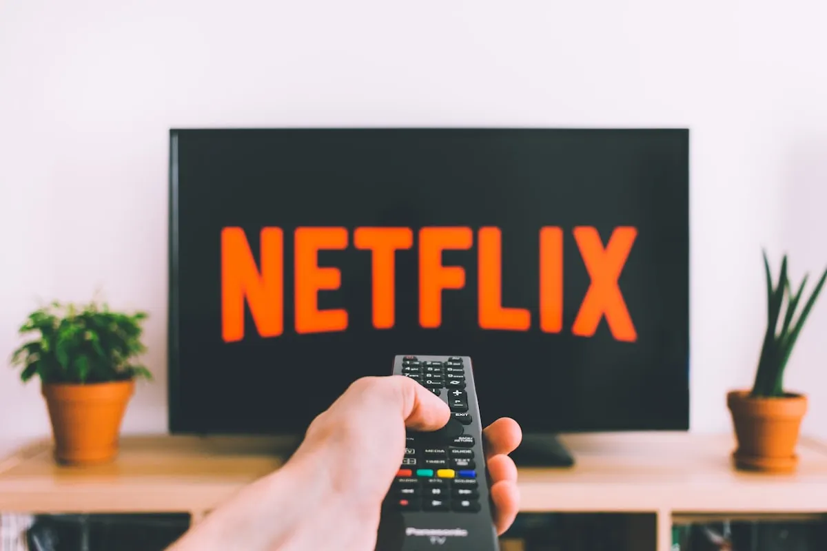 Remote control pointed at a TV showing streaming apps | Photo by Unsplash